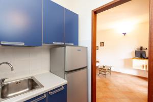 a kitchen with blue cabinets and a stainless steel refrigerator at Villetta Perla Marina 2 in San Teodoro