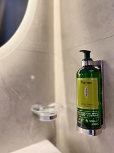 a green bottle of shampoo sitting on a bathroom sink at Cadee Living - Al Nakheel in Riyadh