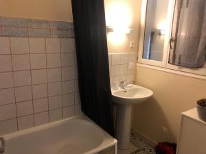 a bathroom with a sink and a bath tub next to a sink at Charmant studio proche centre ville d’Orléans in Orléans