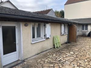 a green chair sitting outside of a house at Charmant studio proche centre ville d’Orléans in Orléans