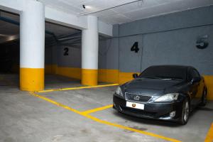 une voiture noire garée dans un garage dans l'établissement PEROLA HOTEl, à Maputo