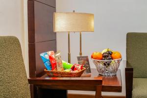 a table with a basket of fruit and a lamp at HOTEL GODWIN DELUXE NEAR CONNAUGHT PLACE Offers FREE AIRPORT PICKUP in New Delhi +145 photos
