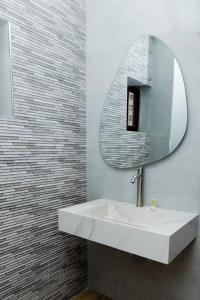 une salle de bain avec un lavabo blanc et un miroir dans l'établissement PEROLA HOTEl, à Maputo