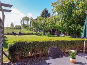 a garden with a hedge and a table with flowers at Ferienwohnungen am Bach in Marlow