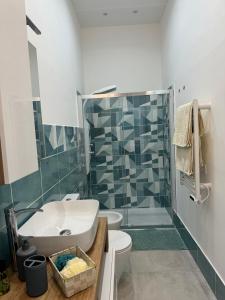 a bathroom with a sink and a toilet and a shower at Angú - Casa Vacanze in Avola +14 photos