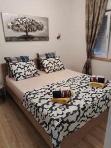 a bed with black and white sheets and pillows at Apartments Hasanovic Rukavac in Podstražje