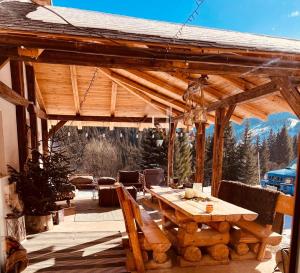 a wooden pavilion with a table and chairs on a patio at Ciumarna Holiday House in Vatra Moldoviţei