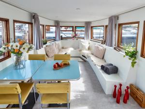 una sala de estar con un sofá y una mesa en Your Houseboat Amsterdam, en Ámsterdam 40 fotos más