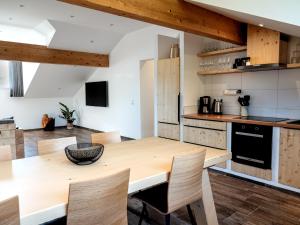 a kitchen with a wooden table and chairs at Landresort MUHRHOF in Drachselsried