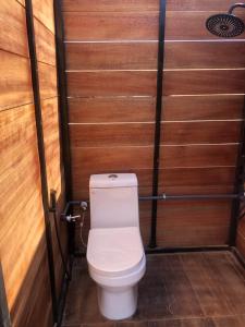 a bathroom with a toilet in a wooden wall at AYLA bidiyah in Badīyah
