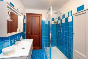 a blue tiled bathroom with a sink and a shower at Villetta Perla Marina in San Teodoro +19 photos