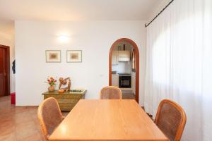 a dining room with a wooden table and chairs at Villetta Perla Marina in San Teodoro