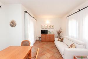 a living room with a white couch and a table at Villetta Perla Marina in San Teodoro