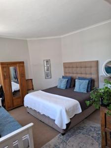a bedroom with a large bed and a mirror at Rising Tide in Fish hoek