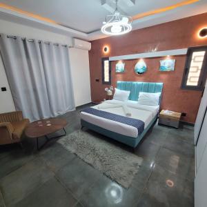 a bedroom with a king sized bed and a table at Chambres d'hôtes saly in Saly Portudal +62 photos