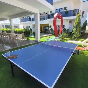 a ping pong table in front of a building with a redlympiclymp at Chambres d'hôtes saly in Saly Portudal