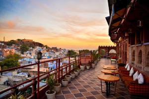 a balcony with tables and chairs and a view of the city at Castle View Heritage Haveli in Jodhpur