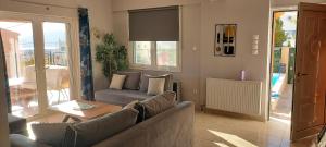 una sala de estar con un sofá y una mesa en Airport Friendly House 1, en Artemida