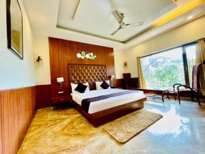 a bedroom with a large bed and a large window at Plutus Luxury Boutique Stays in Mussoorie