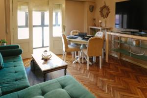 a living room with a green couch and a table at Apartamento plaza Mayor Húmedo con parking incluido in León