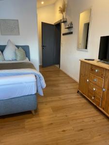 a bedroom with a bed and a dresser with a television at NEST'L Appartements & Zimmer in Mösern +25 photos