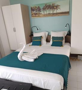 - une chambre avec un grand lit recouvert d'un cygne dans l'établissement GRAND TI-BOU Gwada breizh, à Saint-François