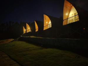 a building with a lit up facade at night at Gambhiraa Resorts in Kolli Hills