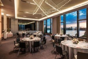 a banquet hall with tables and chairs and large windows at Le Méridien Hamburg in Hamburg