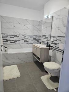 ein Badezimmer mit Toilette, Waschbecken und Badewanne in der Unterkunft Milan Luxury Apartaments VIII #Târgu Mureș in Târgu Mureș
