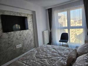ein Schlafzimmer mit einem Bett und einem Fernseher an der Wand in der Unterkunft Milan Luxury Apartaments VIII #Târgu Mureș in Târgu Mureș