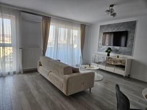ein Wohnzimmer mit Sofa und Fernseher in der Unterkunft Milan Luxury Apartaments VIII #Târgu Mureș in Târgu Mureș
