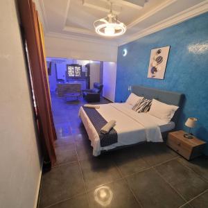 a bedroom with a bed and a blue wall at Studio à louer dans une maison d hôtes in Saly Portudal +54 photos