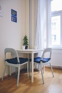 una mesa blanca con 2 sillas y una maceta en Augarten Residences, en Viena