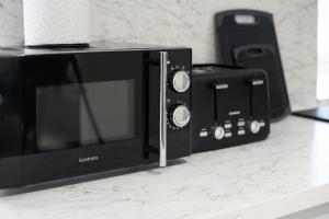 a microwave and a toaster oven on a counter at Modern 5 BED-2 BATH Apartment in Galashiels