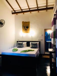 1 dormitorio con 1 cama grande y toallas verdes en Sh li, en Sigiriya