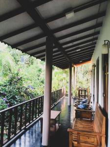 un porche de una casa con bancos y árboles en Sh li, en Sigiriya