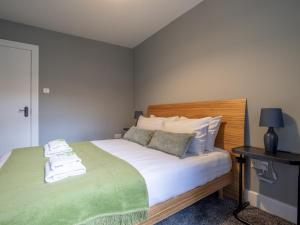 a bedroom with a bed with green and white sheets at Pass the Keys Happy Haven Home, West End in Glasgow