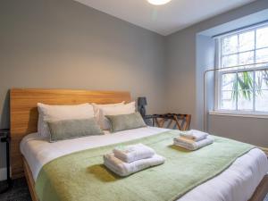 a bedroom with a large bed with towels on it at Pass the Keys Happy Haven Home, West End in Glasgow