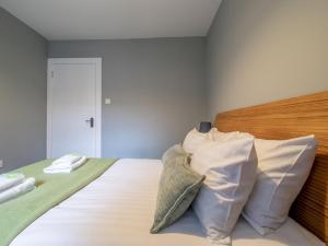 a bedroom with a bed with a wooden headboard and pillows at Pass the Keys Happy Haven Home, West End in Glasgow