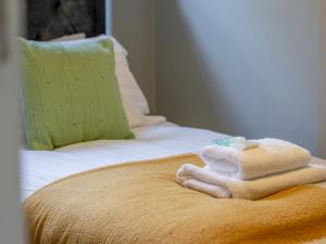 a pile of towels sitting on top of a bed at Pass the Keys Happy Haven Home, West End in Glasgow