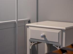 a small white table with a drawer and a mirror at Pass the Keys Happy Haven Home, West End in Glasgow