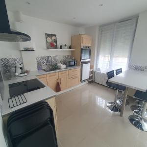 una cucina con un bancone e un tavolo con sedie di Maison a Ambrault Altre 7 foto