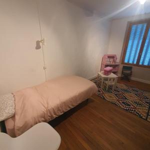 una camera da letto con un letto, una sedia e una finestra di Maison a Ambrault