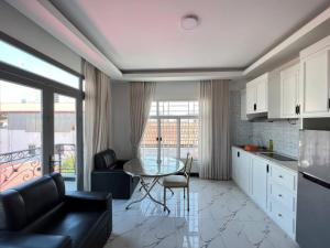 a kitchen and living room with a table and a couch at Jasminsorium in Phnom Penh