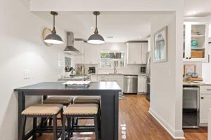 a kitchen with a black island with stools at Tranquility - 4318 Tenth Street in Saint Simons Island