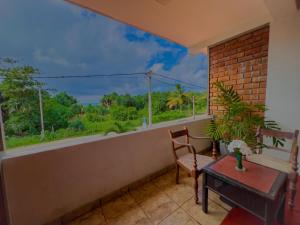 a balcony with a table and chairs and a window at Ocean Wave Hikakduwa in Hikkaduwa
