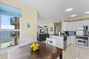 Una cocina con una mesa con un bol de fruta encima. en Beach Colony East 7A, en Perdido Key