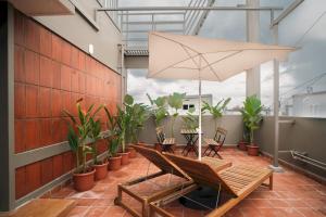 a balcony with a chair and an umbrella at Heiwa by Hodo stays in Bengaluru