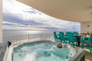 a hot tub on a balcony with chairs and the ocean at Turquoise Place 1108 D in Orange Beach