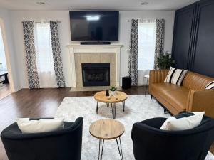 a living room with a couch and chairs and a fireplace at The Cozy Haven in Owasso